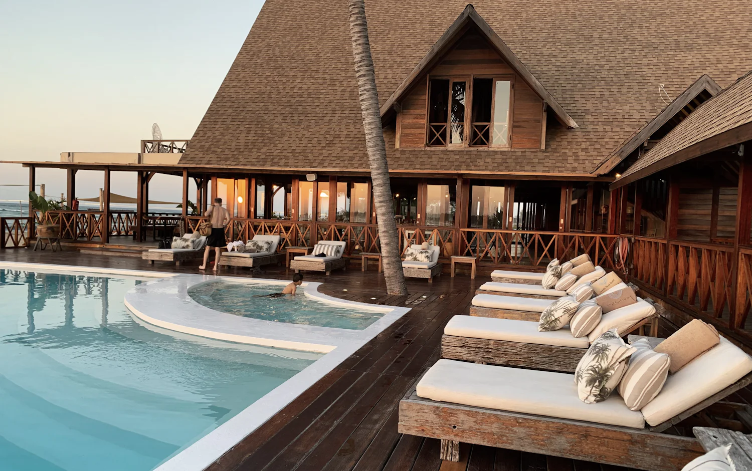 Resort villa and loungers beside the water